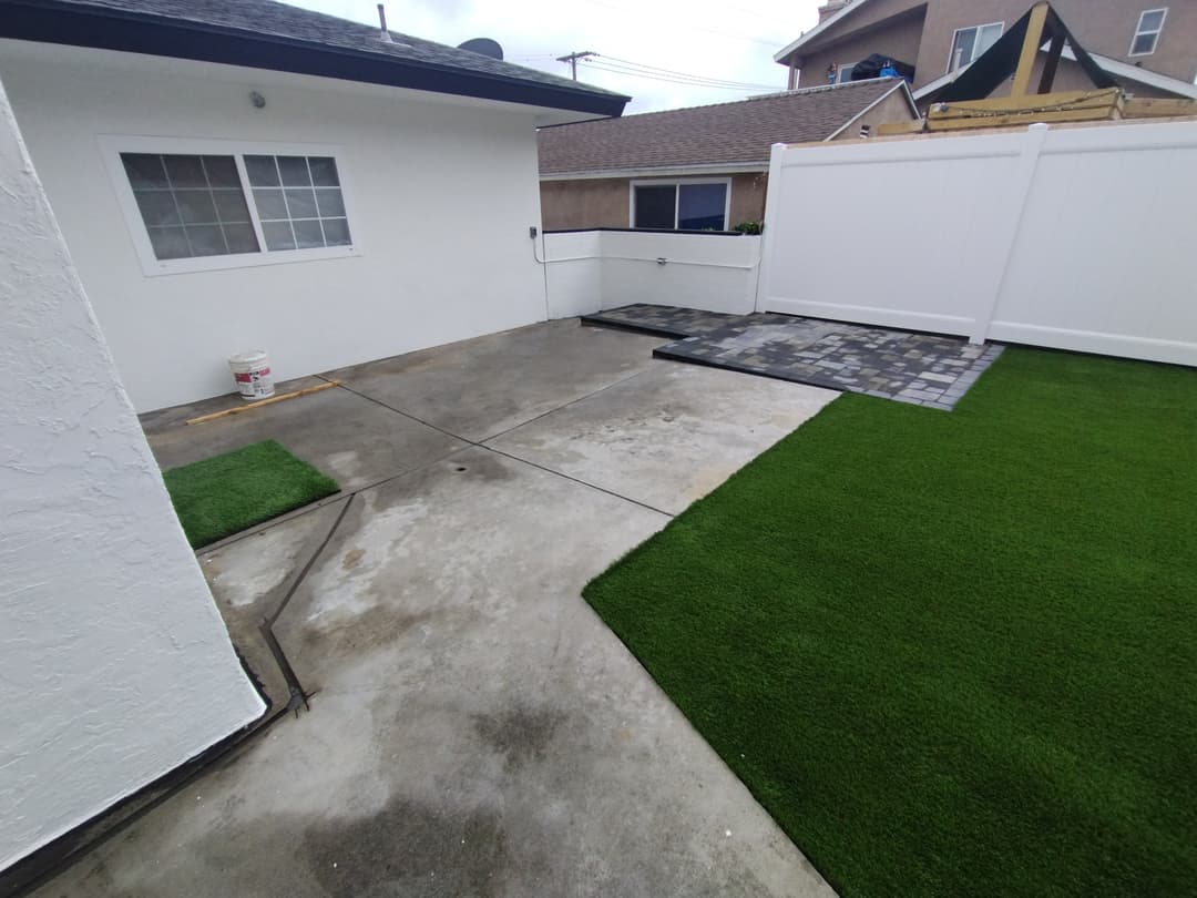 backyard with pavers, artificial turf, and vinyl fence